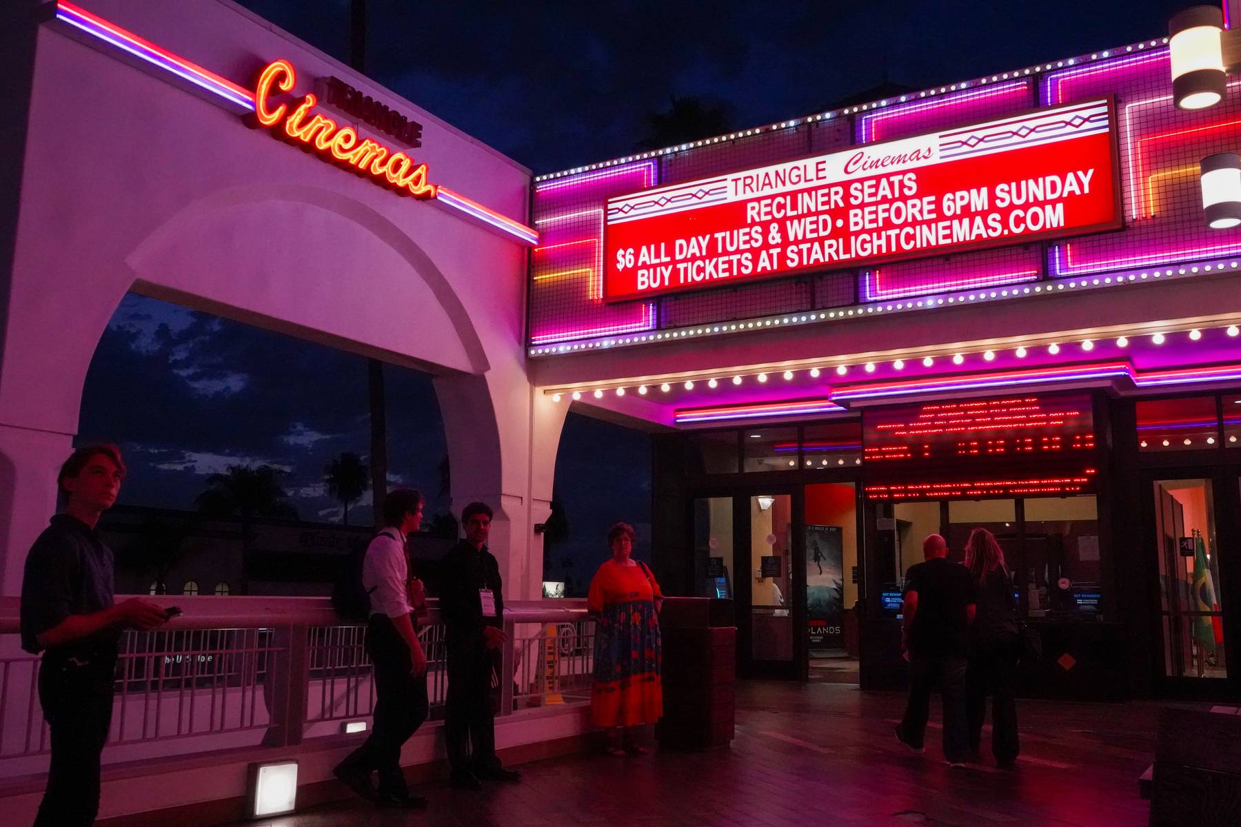 Starlight Cinemas marquee lit in pink and red at night