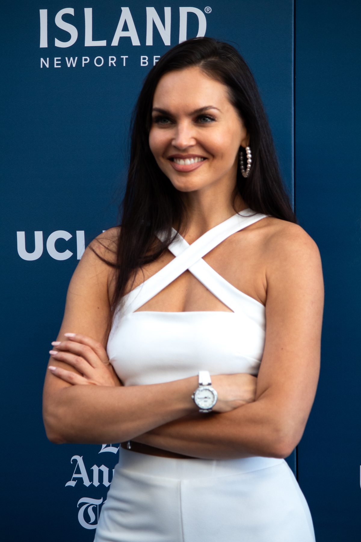Woman in white posing in front of the festival backdrop