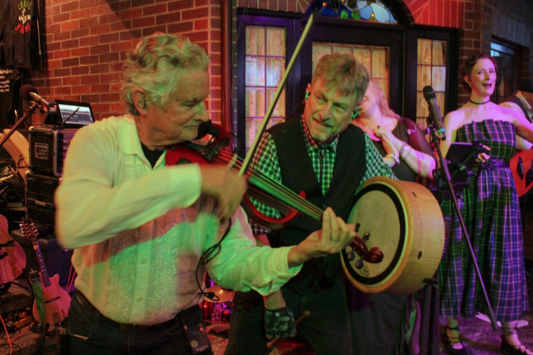 Musicians playing fiddle and bodhran at the festival after party