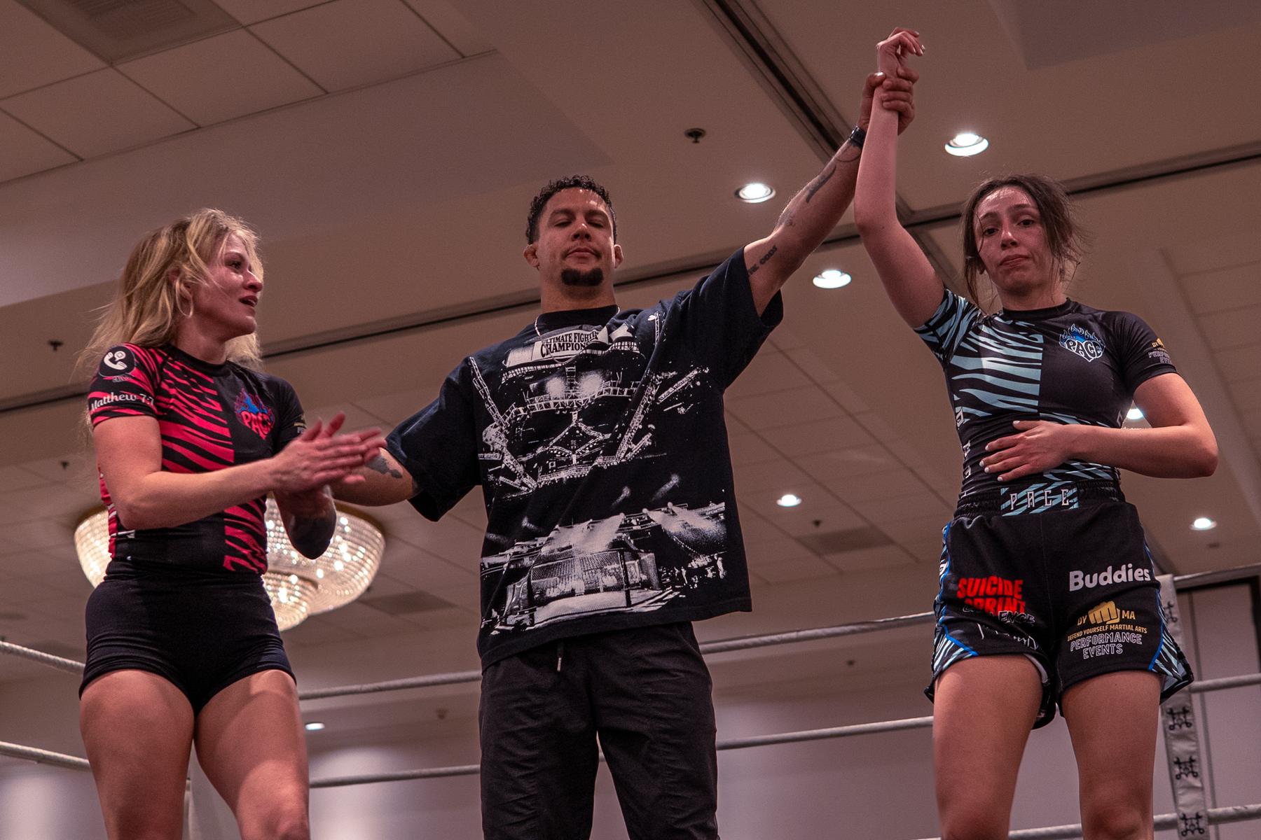 Referee raising a fighter's hand after the match at Pace Combat