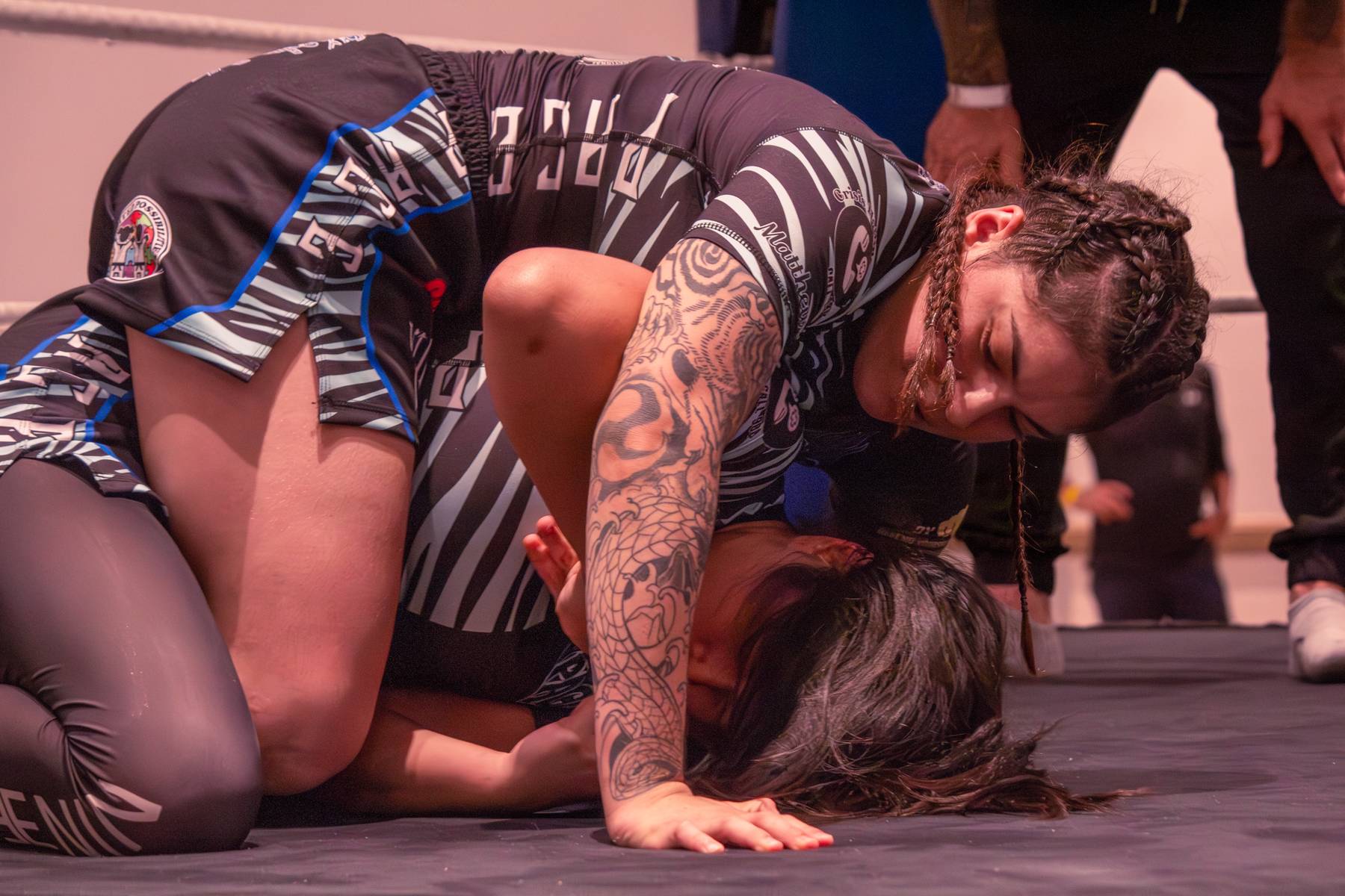 Grappling on the mat during a BJJ match