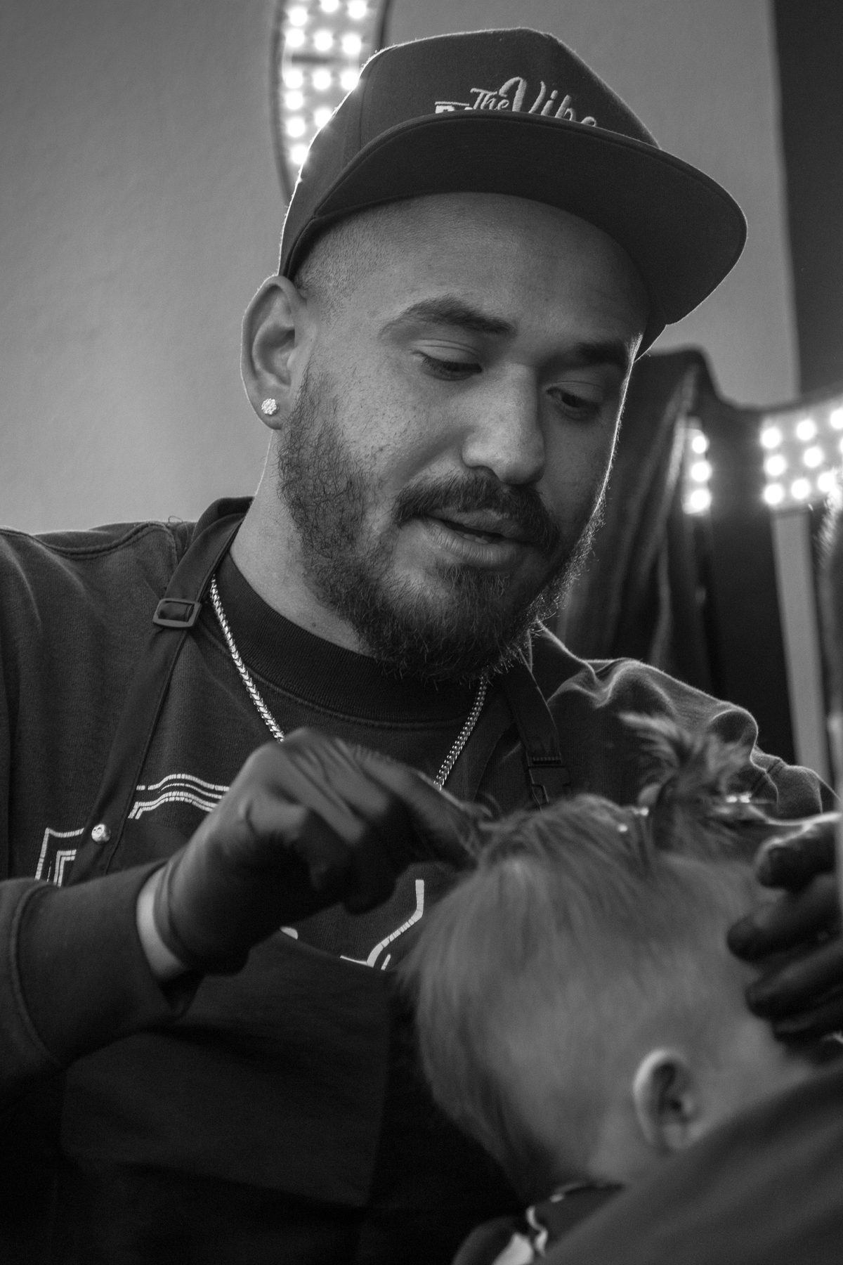 Black and white portrait of a barber cutting a child's hair