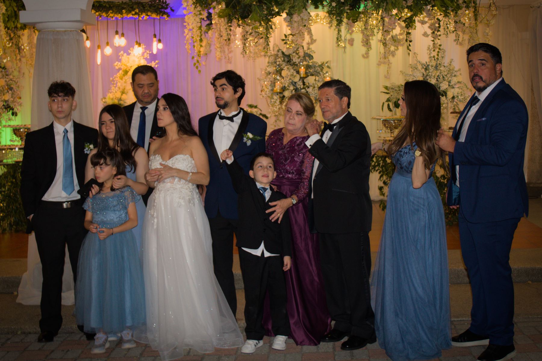 Wedding party and family posing together under the pavilion