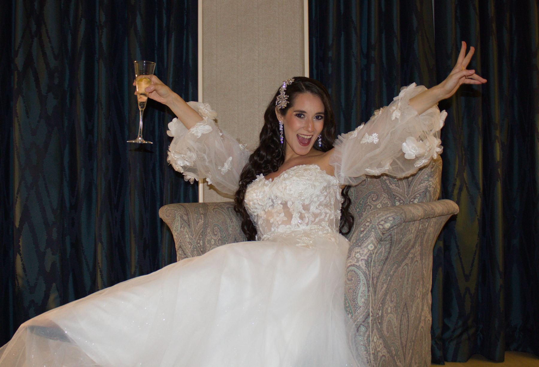 Bride in a flowing gown raising her glass in celebration
